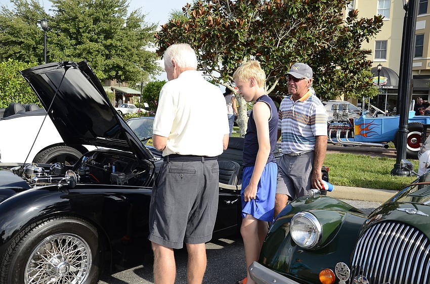 Soren Svenningsen and his grandson Lucas, 13, talk to Mike Bohardt, a Tara Golf and Country Club resident, about his 1960 Triumph TR3. Svenningsen said he's 