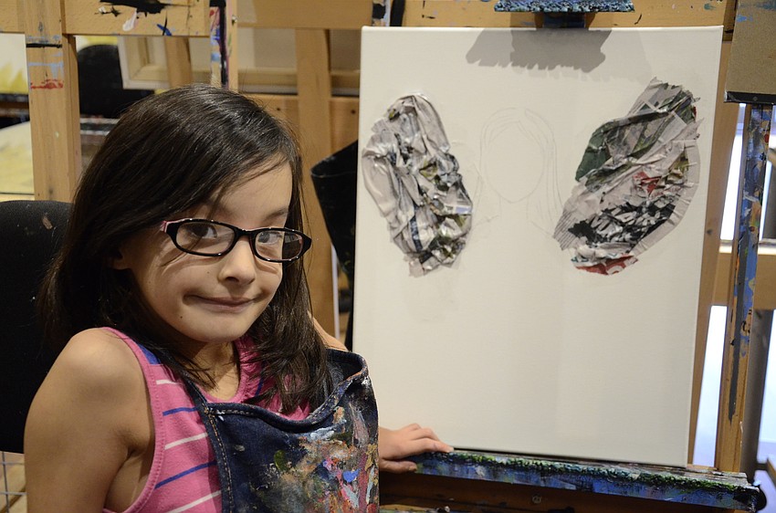 Valentina Alvarez works on her project, which is a fairy with wings made from newspaper.