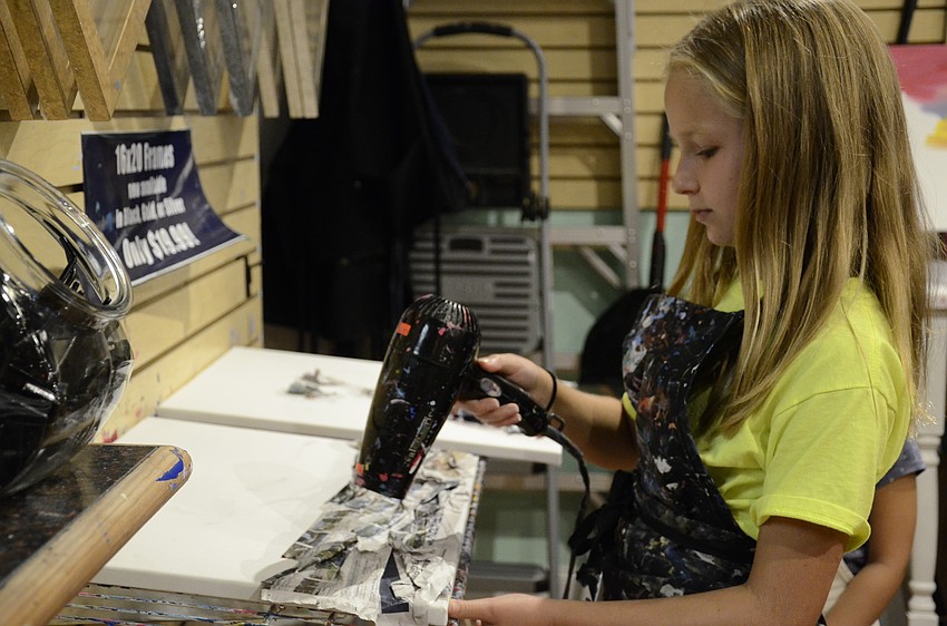 Marissa Vieth dries her newspaper project.