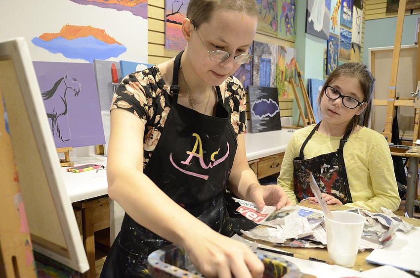 Asia Akhmetova wets newspapers for Olivia Sherry's project.