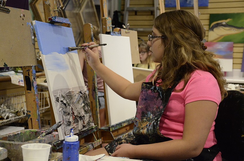 Alexis Inelisano paints a sky onto her project, which she wants to ultimately become a ocean with a dolphin jumping out.