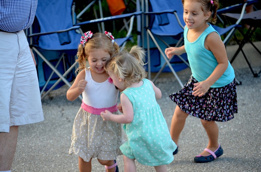 Emily and Aubree Stultz dance around with their younger friend, Teagan Portale.
