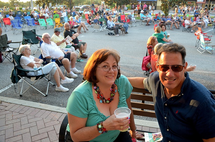 Francesca Veglia and Dan Hoffman enjoy the free concert from the shopping strip.