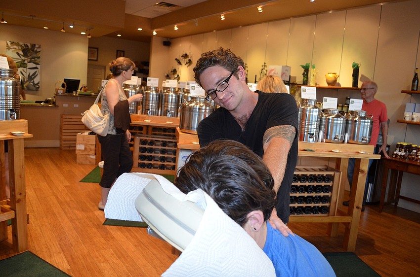 Joshua Mauro, a massage therapist, offers massages to Main Street goers during the event.