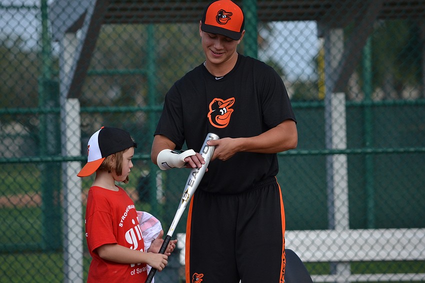 Orioles Minor League player Tristan Graham gives tips to Kylie Morrison.