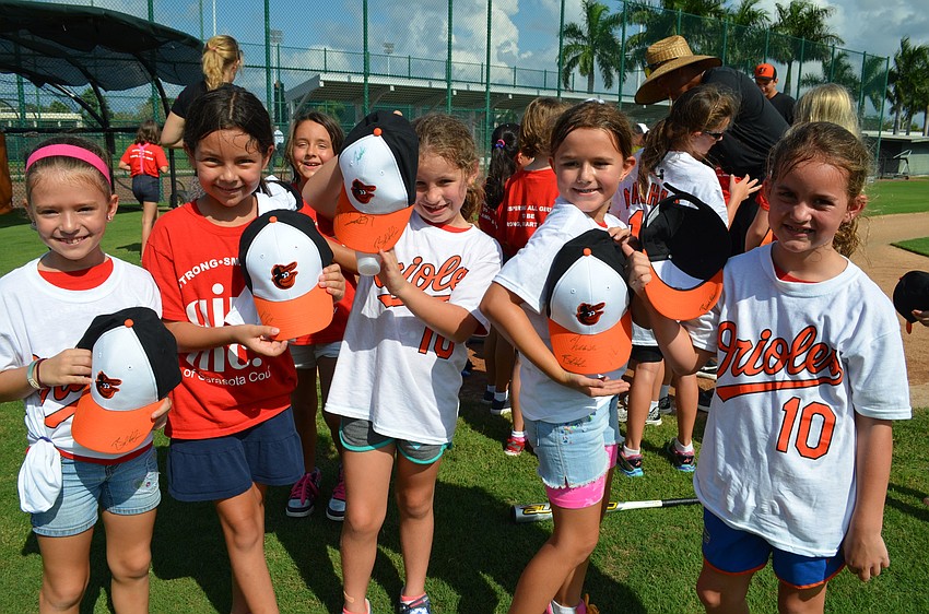 Girls show off their baseball gear that players also signed.