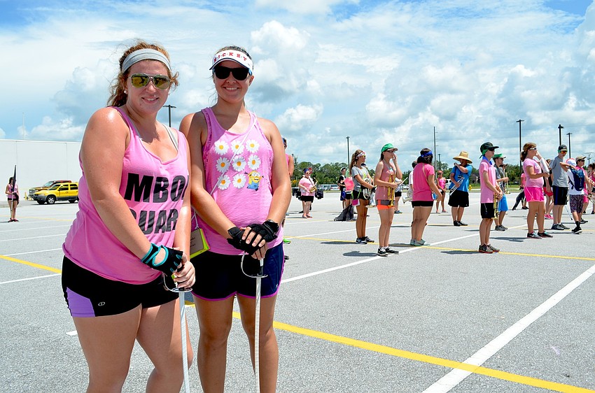 Braden River High flag team members Miranda Gratz and Haley Beyerlein practice alongside the marching band.