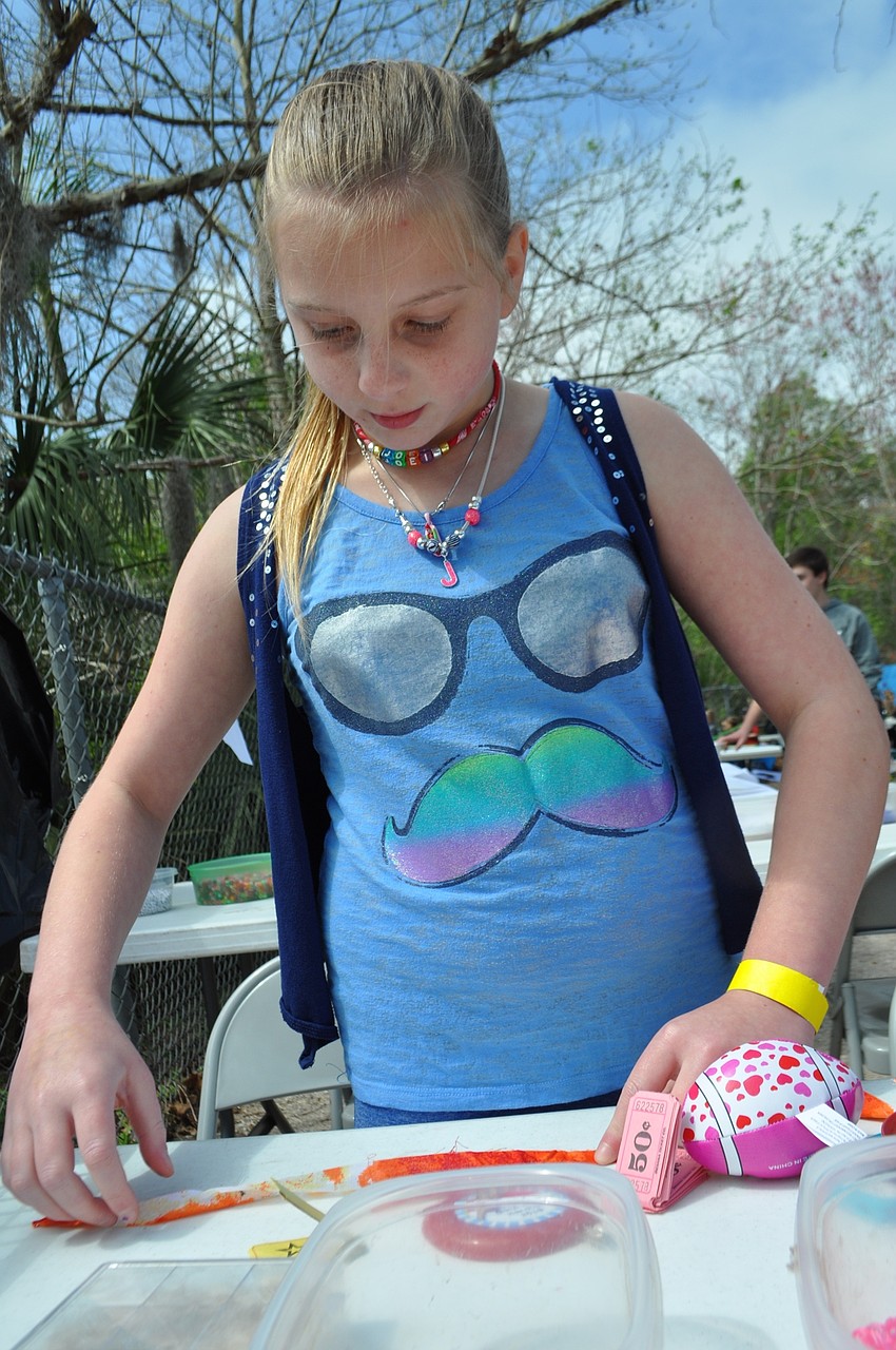 Joei Friese, 10, makes a bracelet.