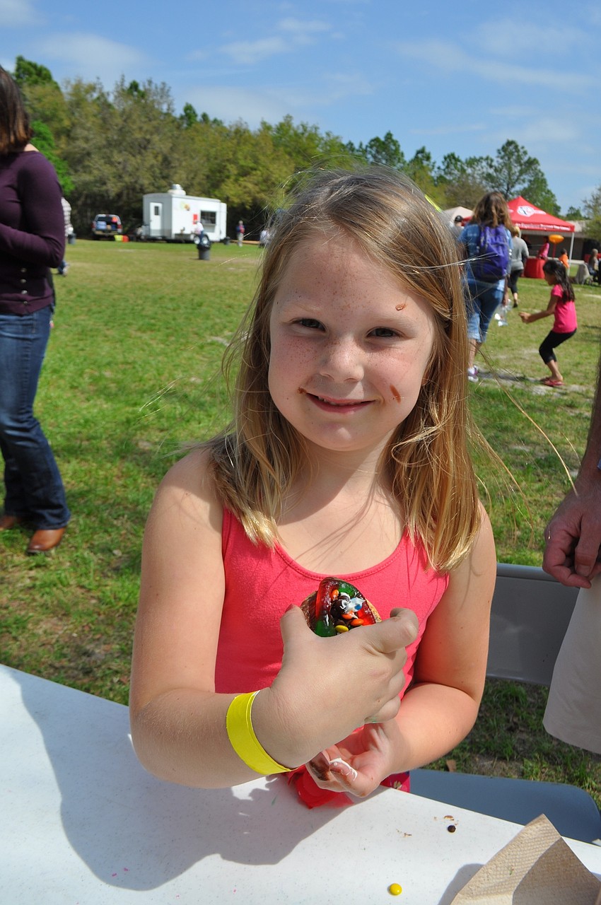 Jenna Chambers, 5, decorates her sugar cookie with everything — three colors of frosting, M&Ms, sprinkles and a giant gummy worm.