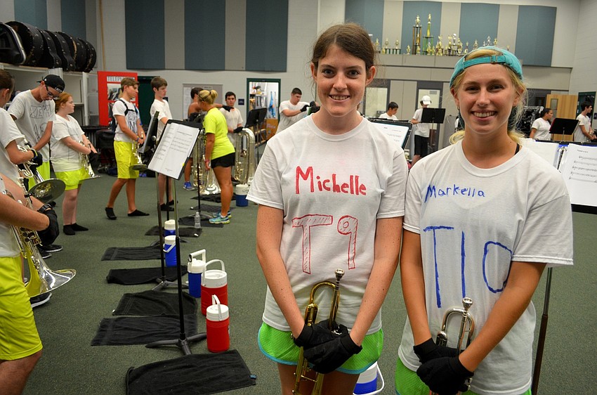 Michelle Matheson and Markella Wagner take a quick break from playing their trumpets.