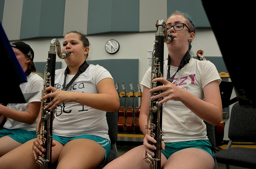 Jessica Zelitt and Lizzy Terwilliger read sheet music while playing the bass clarinet.