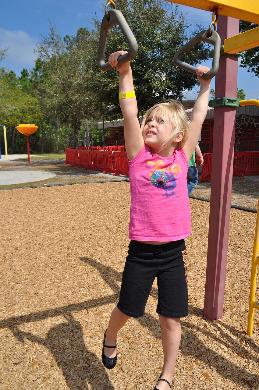 Madison Lane tries out the monkey bars.