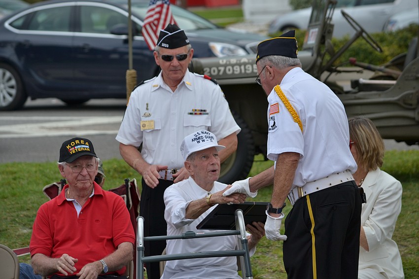 Owner of the Unconditional Surrender statue Jack Curran receives a certificate for his contribution.