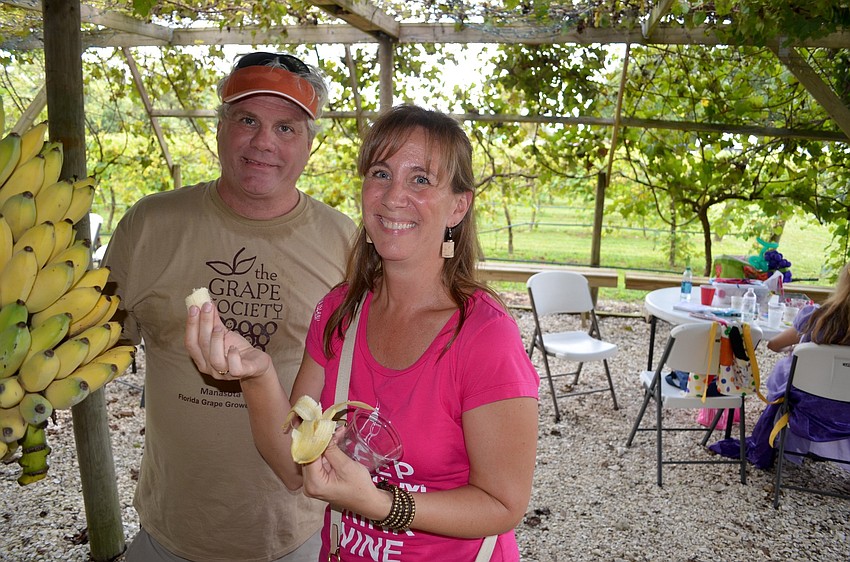 Ed Mehrman, of Sun Fresh Produce, serves up bananas, mangos and other fruits to Traci Kundrat and other attendees.