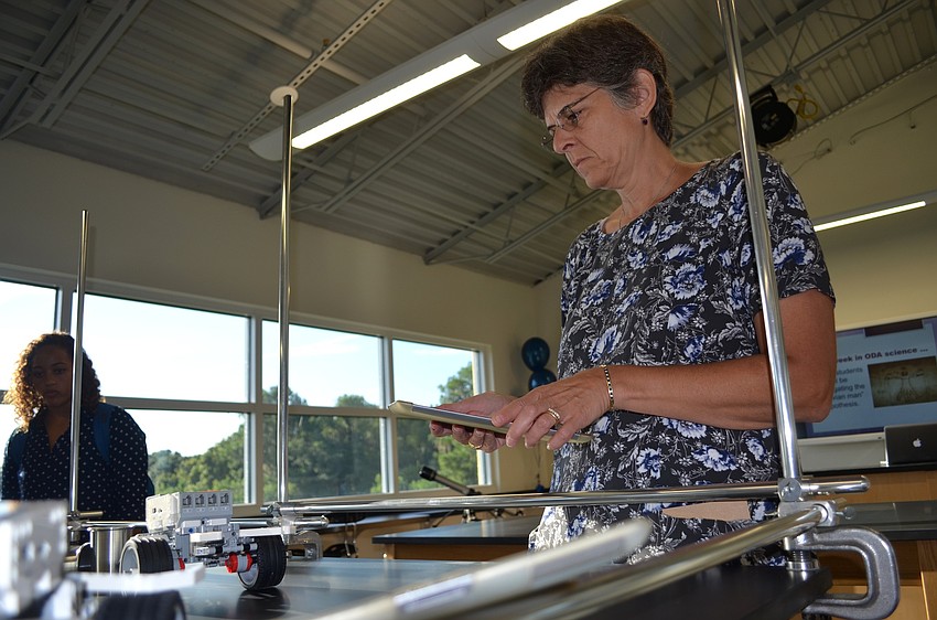Computer Science teacher Joanne Barett maneuevers a remote controlled vehicle in her new work space in the DART STEM Center.
