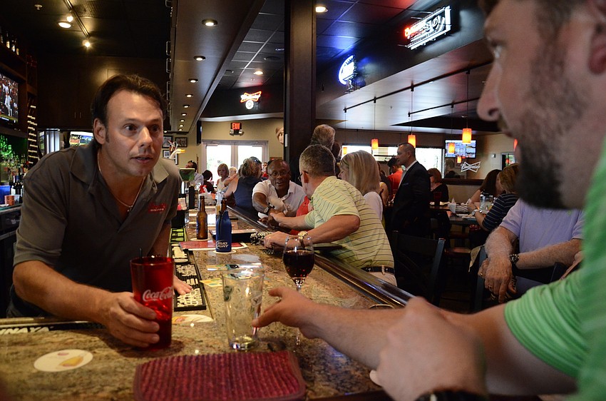 Cash Shelton, franchise owner of Freddy's Frozen Custard, takes an order from Ryan Long, who works at the rescue. Shelton volunteered to be a celebrity bartender for the event.