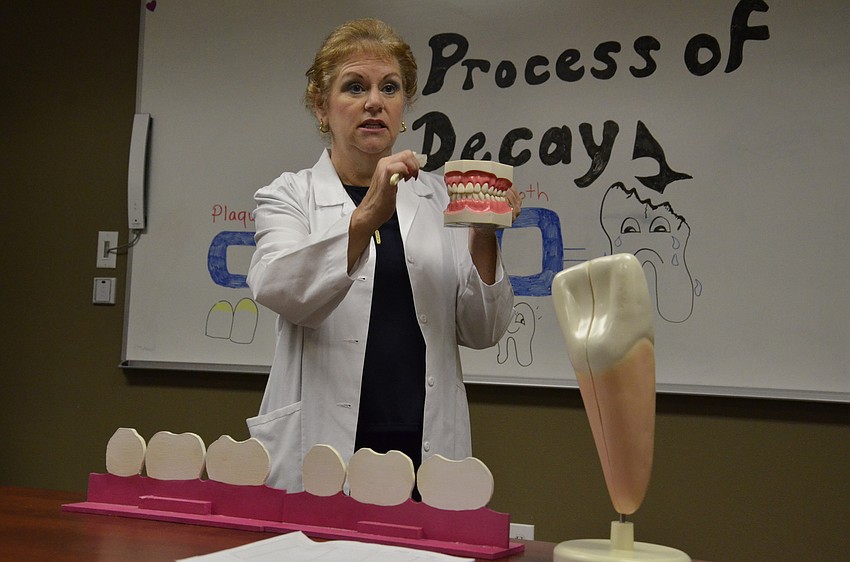 Rhonda Noval, a certified dental assistant at Meridian, teaches children and parents about how to properly brush teeth.