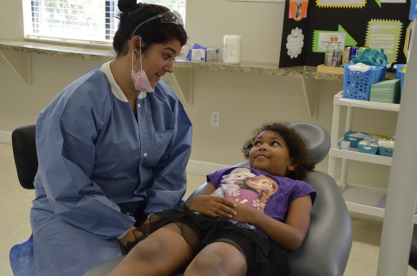 Megan Bardwick talks with Jaidyn Roberts, 7, before cleaning her teeth.