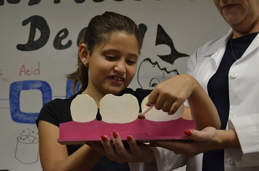Gianna Munoz, 9, shows how to floss.