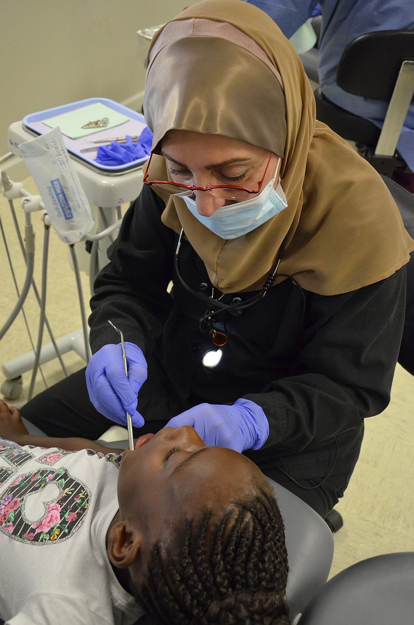 Dr. Eftekhar Arshadi with Siesta Family Dentistry works on 6-year-old Ziahana Sims' teeth.