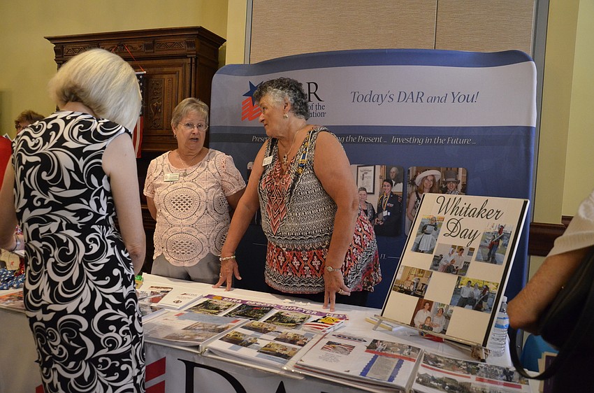 Diane Kingery Gentsch talks with Clarissa Thomasson and Barbara Wilkes Asony at the Saramana chapter of Daughters of the American Revolution booth.