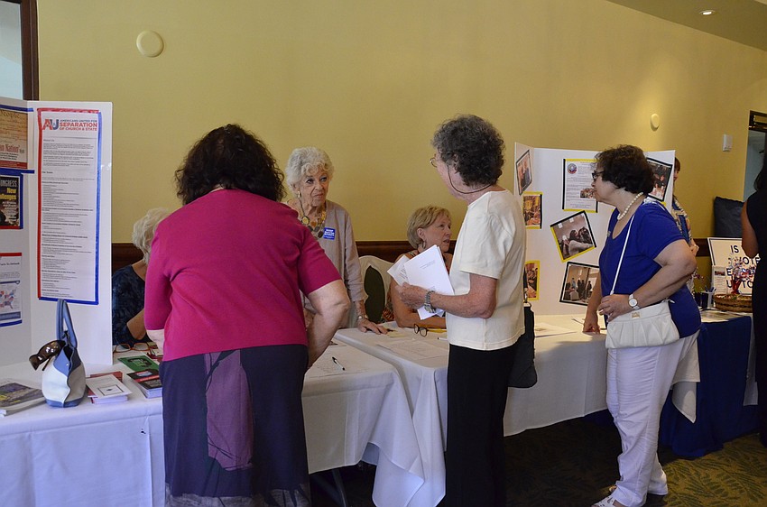 Arlene Pearlman, president of the Sarasota Manatee chapter for Americans United for the Separation of Church and State, talks with visitors to her booth.