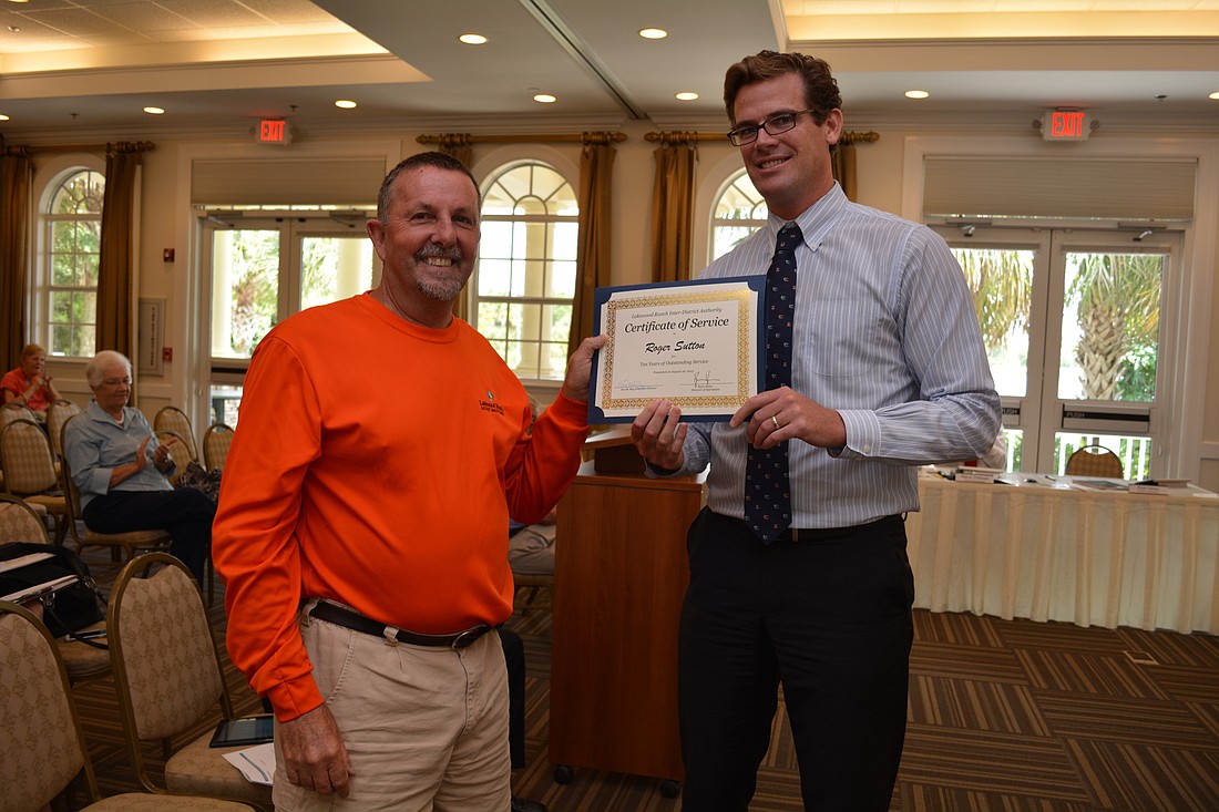 Roger Sutton receives his 10-year service award from Ryan Heise, director of operations of Lakewood Ranch Town Hall.