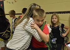 Laura Sherry gives her son, Luke, 8, one last hug before he starts his third-grade class.