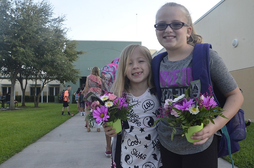 Gabbi Hotaling, 7, and older sister Maddie, 10, brought a bouquet of flowers for their teachers on the first day of school. Maddie said the two of them do this for their teachers every year.