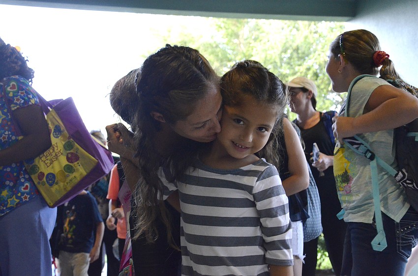 Caty Freyre gives her daughter, Mia, 5, a kiss before walking her to her kindergarten class. Mia already loves her teacher, Ms. Paoli. 