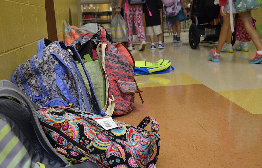 Backpacks lined the hall before the cafeteria.