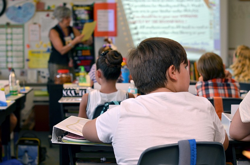 Teachers go over first day of school business in the classroom.