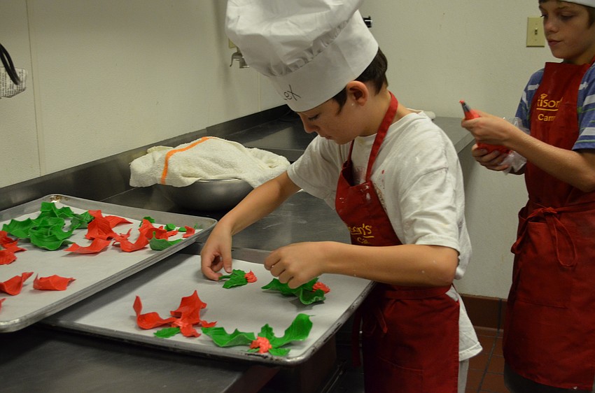 Alex Jodwalis creates holly leaves with sugar and frosting.