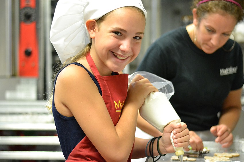 Ema Chirnside pipes icing on to a gingerbread man.