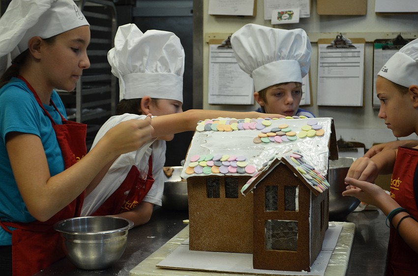 Campers help decorate a gingerbread house for the Mattison's Forty-One Chef Camp.