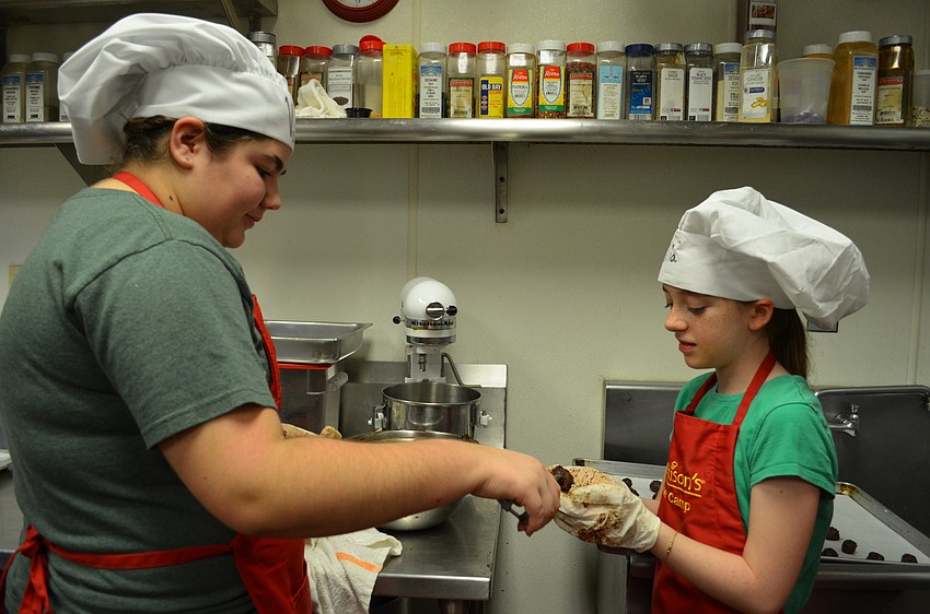 Valerie Wojcik and Julia Holland help make chocolate truffles.