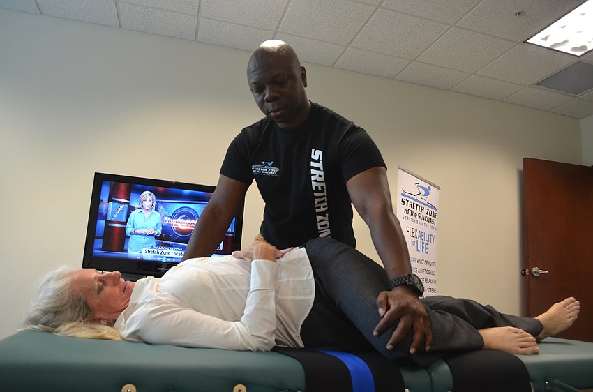 Keiser graduate Teresa Mock receives stretching advice from Kevin Hall, of Stretch Zone, during a demonstration.