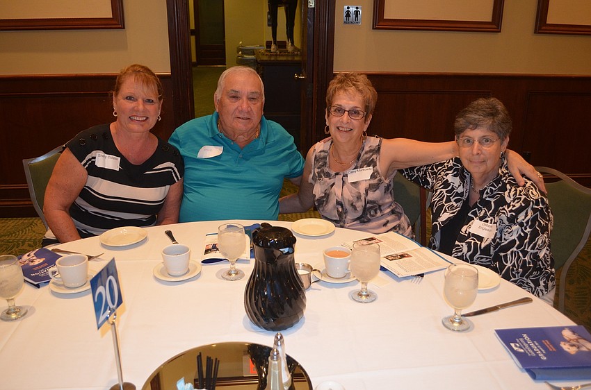 Shelby Colston, Dick Neaves, Cathy Markowitz and Debbie Engleson huddle around their table, while waiting for their meals.