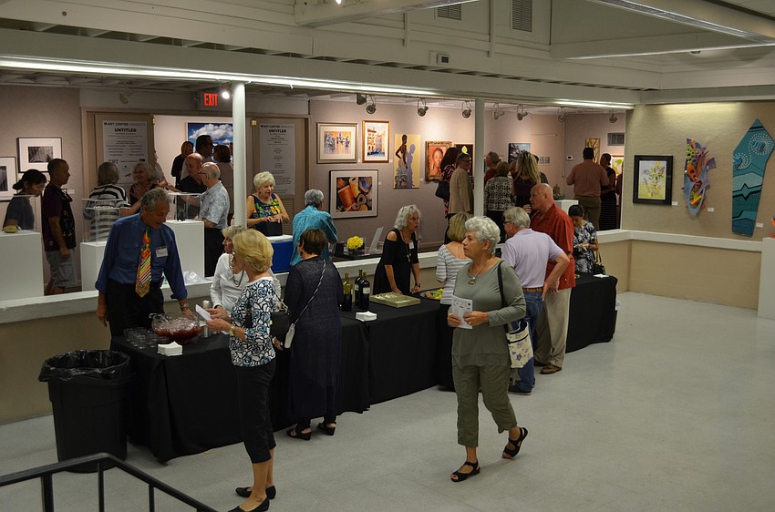 Artists and art enthusiasts venture through the gallery and enjoy some refreshments.