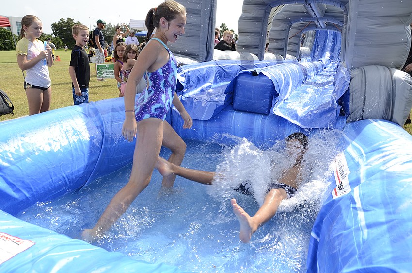 Ella Flett, 12, and her brother, Owens, 10, slide down the monster slide together.