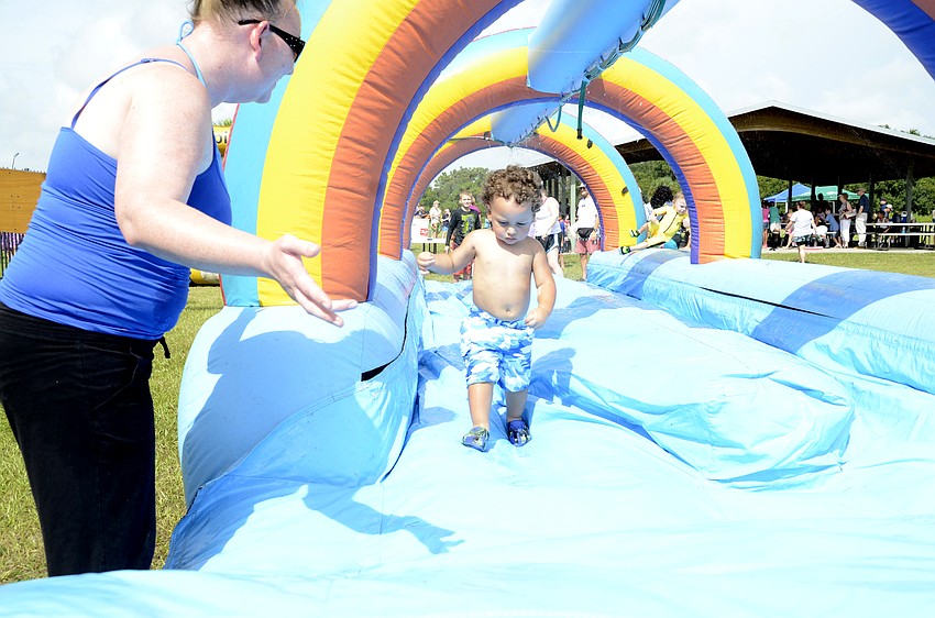 Heather Lashua waits for son Ce'zar Lorquet, 1, to make his way down the slip-n-slide.