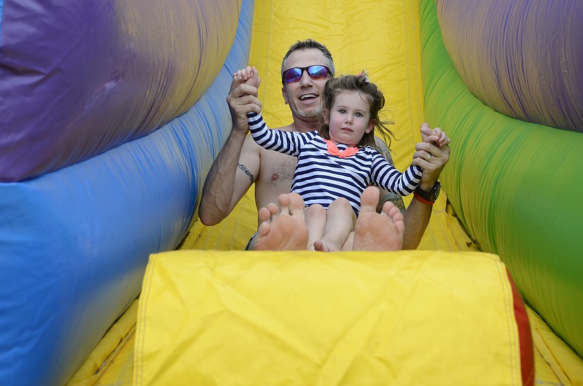 Jason Quintal and daughter Daphne, 2, slide down together.