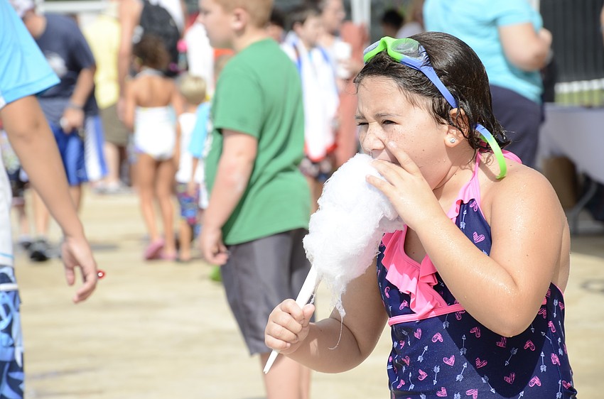 Sofia Mast, 7, gets a bite of cotton candy from the Lakewood Ranch Dental booth (whose representatives encouraged everyone to brush their teeth after snacking).