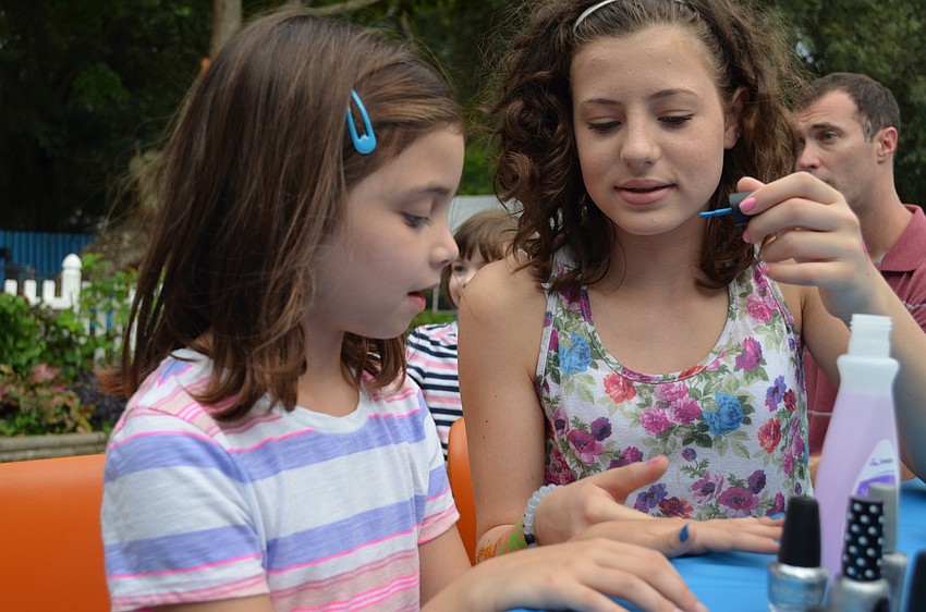 Tayla Rosenthal paints Natalie Ceaser's nails an electric shade of blue.