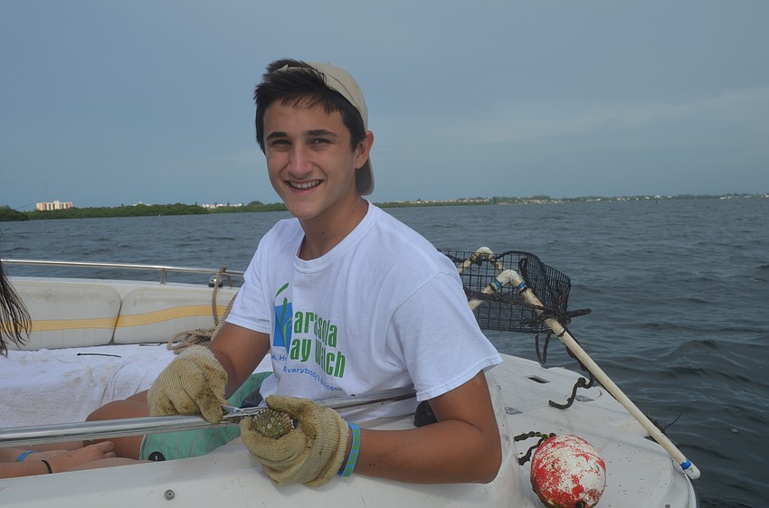 Jack Martin, 15, cleans a scallop.