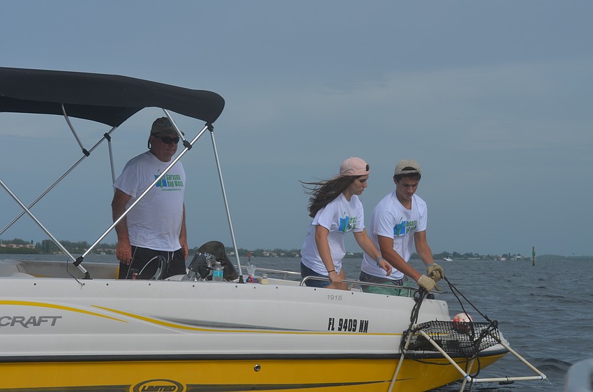 Steve, Ellie and Jack Martin check on a scallop sanctuary.