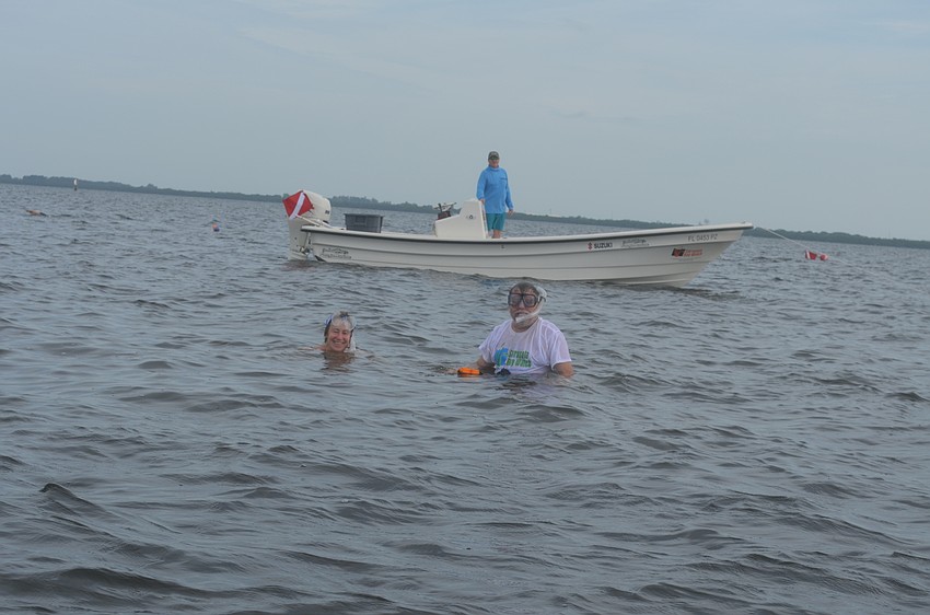 Beth and Scott Brewer search for scallops from Steve Traves’ boat.