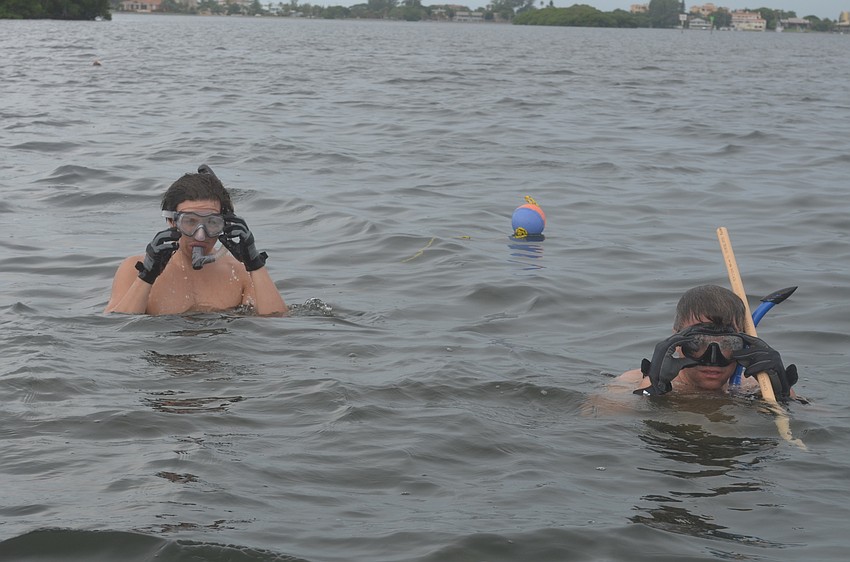 John Okovach and Jeff Schaefer search for scallops.