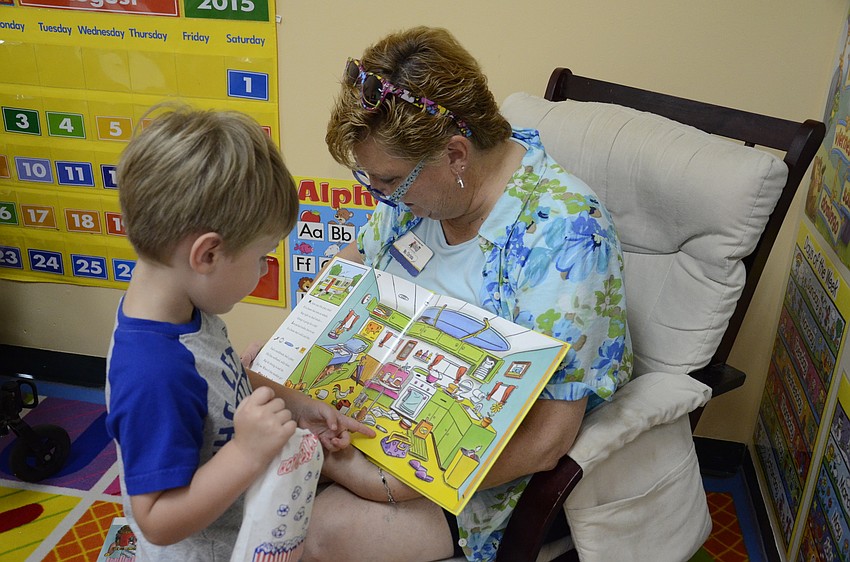 Christa Briener, the voluntary pre-kindergarten teacher, reads a bok to Nolan Lee, 4.