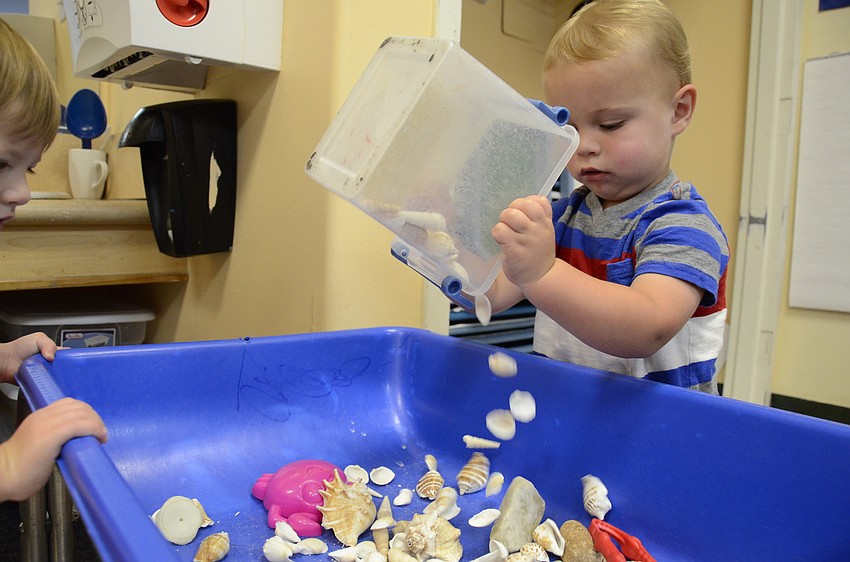 Easton Lee, 1, dumps out some sea shells.